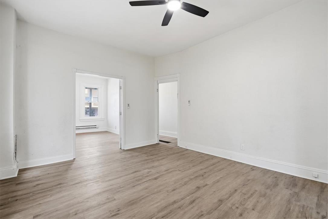 812 Linden Street Bethlehem, PA 18018 - Photo 3 of 39 A versatile living area features durable vinyl plank flooring and a modern ceiling fan for comfort.