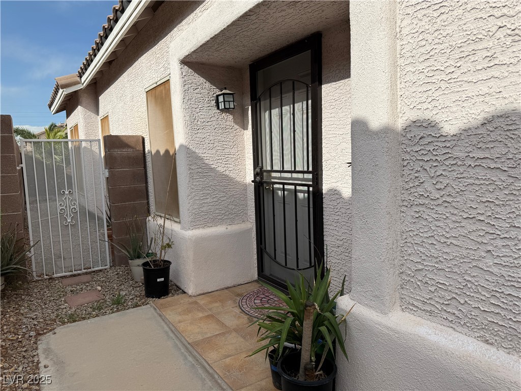 7062 Russell Ranch Avenue Las Vegas, NV 89113 - Photo 5 of 32 Entrance to property featuring a tile roof and stucco siding
