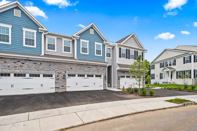 a front view of a building with streets and trees