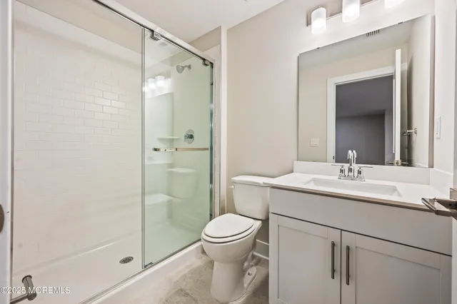 a bathroom with a granite countertop sink toilet a mirror and shower