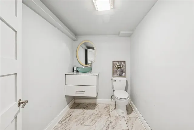a bathroom with a toilet sink and mirror