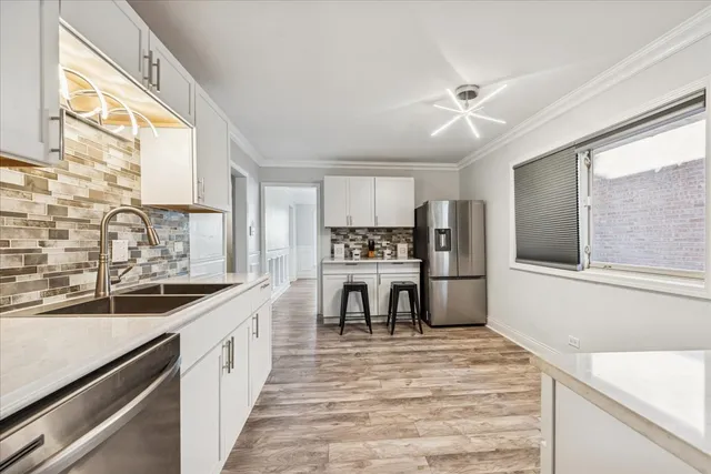 a kitchen with stainless steel appliances kitchen island granite countertop a sink stove and refrigerator