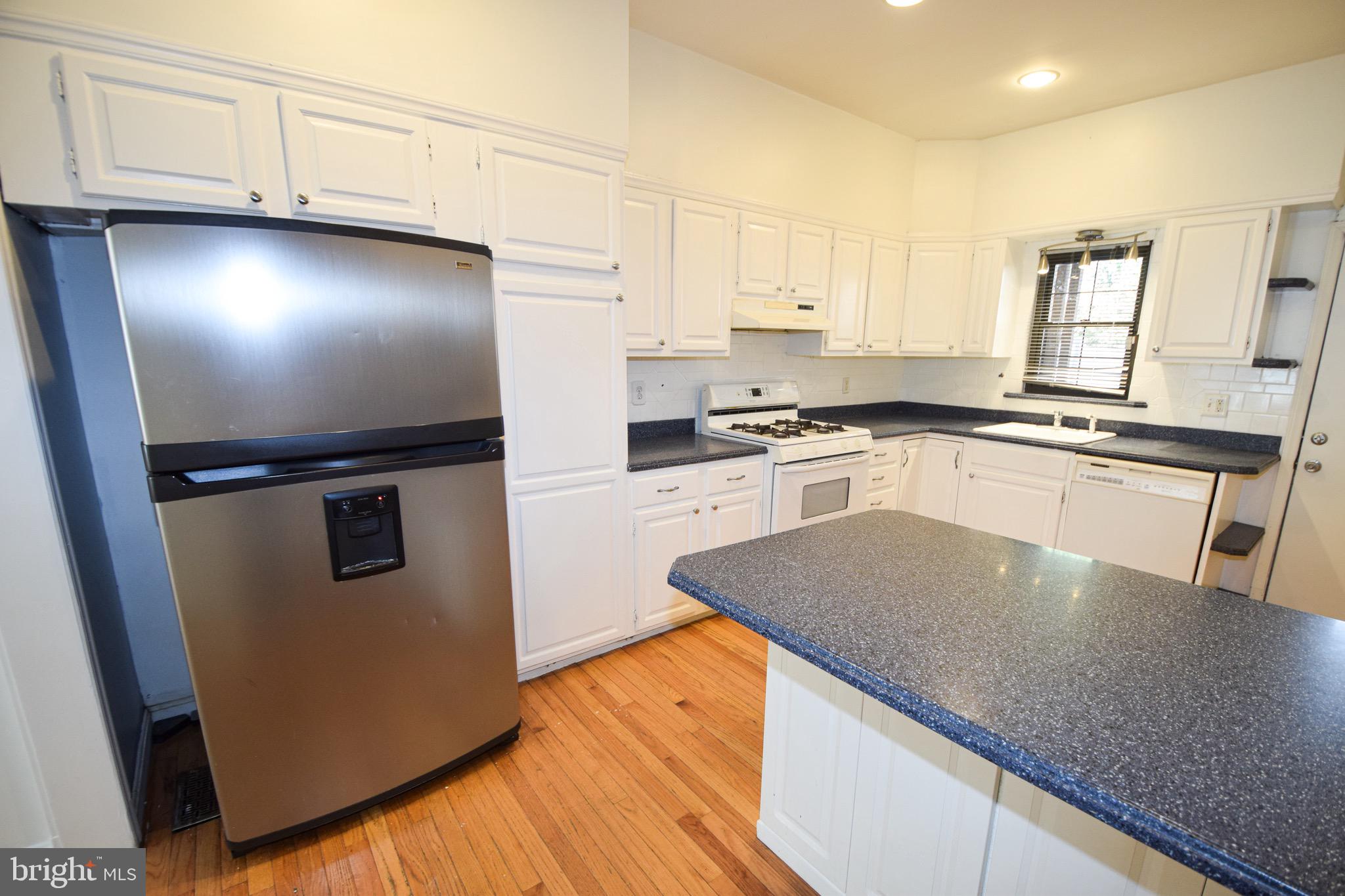 3606 Hudson Street Baltimore, MD 21224 - Photo 13 of 52 a kitchen with granite countertop a refrigerator and a stove top oven