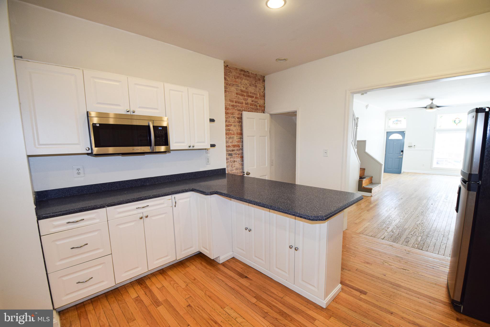 3606 Hudson Street Baltimore, MD 21224 - Photo 16 of 52 a kitchen with granite countertop white cabinets and stainless steel appliances