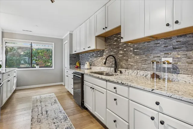 a kitchen with granite countertop a sink stainless steel appliances and cabinets