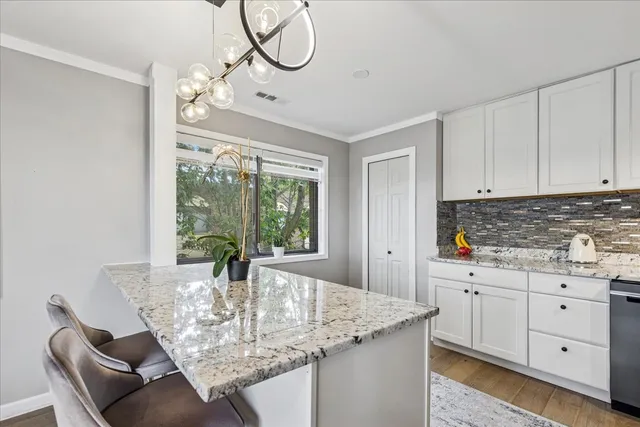 a dining table with a large window and kitchen view