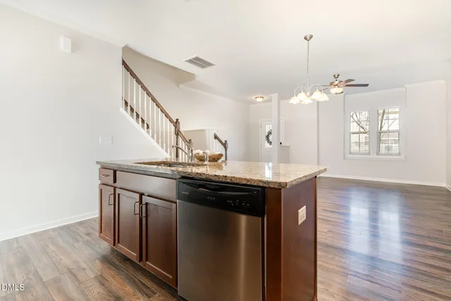 a kitchen with a refrigerator a stove top oven a sink and cabinets