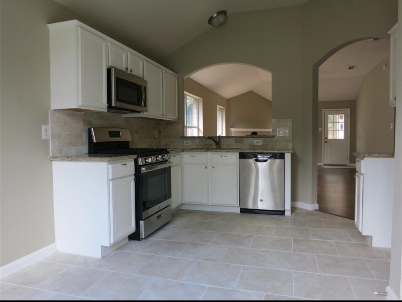 5235 Sherilynn Drive Spring, TX 77373 - Photo 6 of 11 a kitchen with stainless steel appliances a stove a microwave sink and cabinets