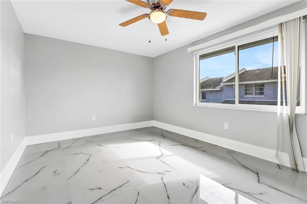 15 Watercolor Way, Unit 15 Naples, FL 34113 - Photo 21 of 29 an empty room with windows and ceiling fan