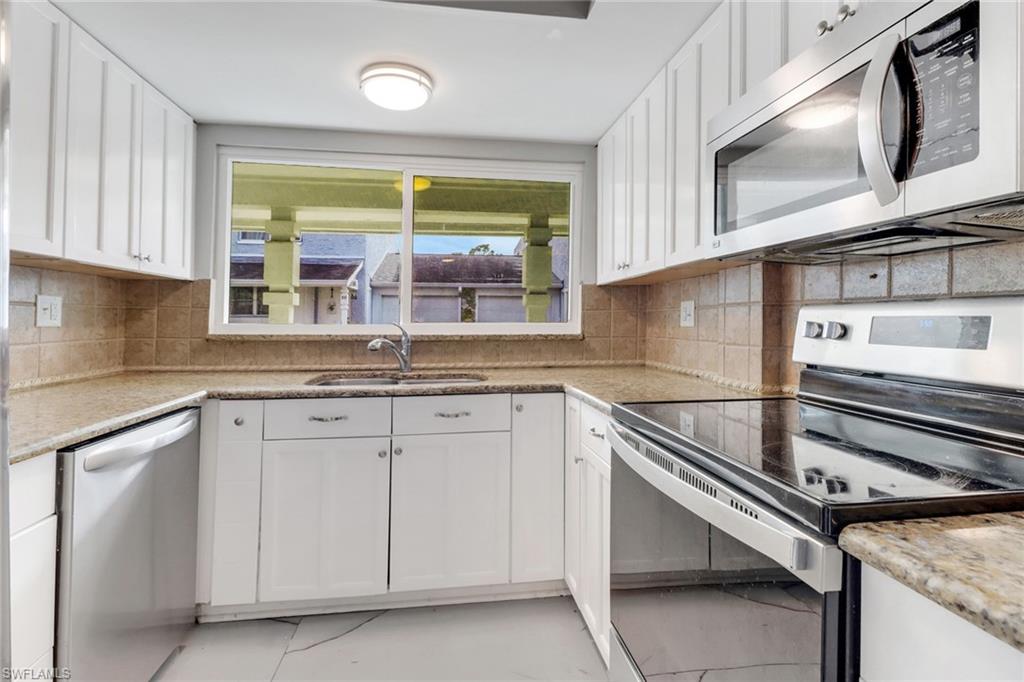 15 Watercolor Way, Unit 15 Naples, FL 34113 - Photo 6 of 29 a kitchen with granite countertop stainless steel appliances a sink stove and cabinets