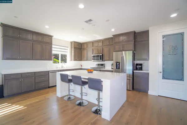 a kitchen with stainless steel appliances granite countertop a refrigerator and a sink