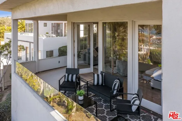 a living room with furniture and large windows