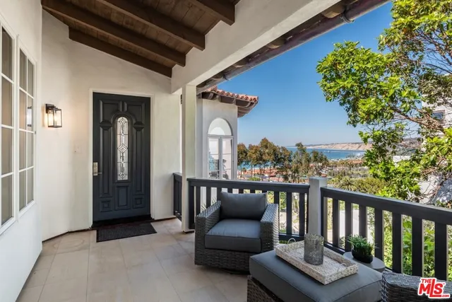 a view of a balcony with chairs and a flower plants