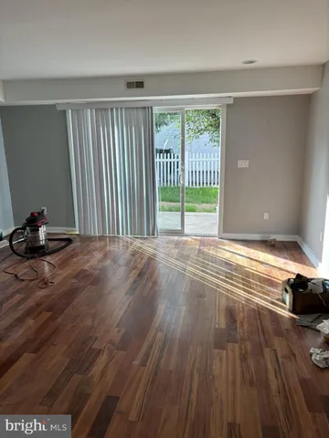 a view of a room with wooden floor and a window