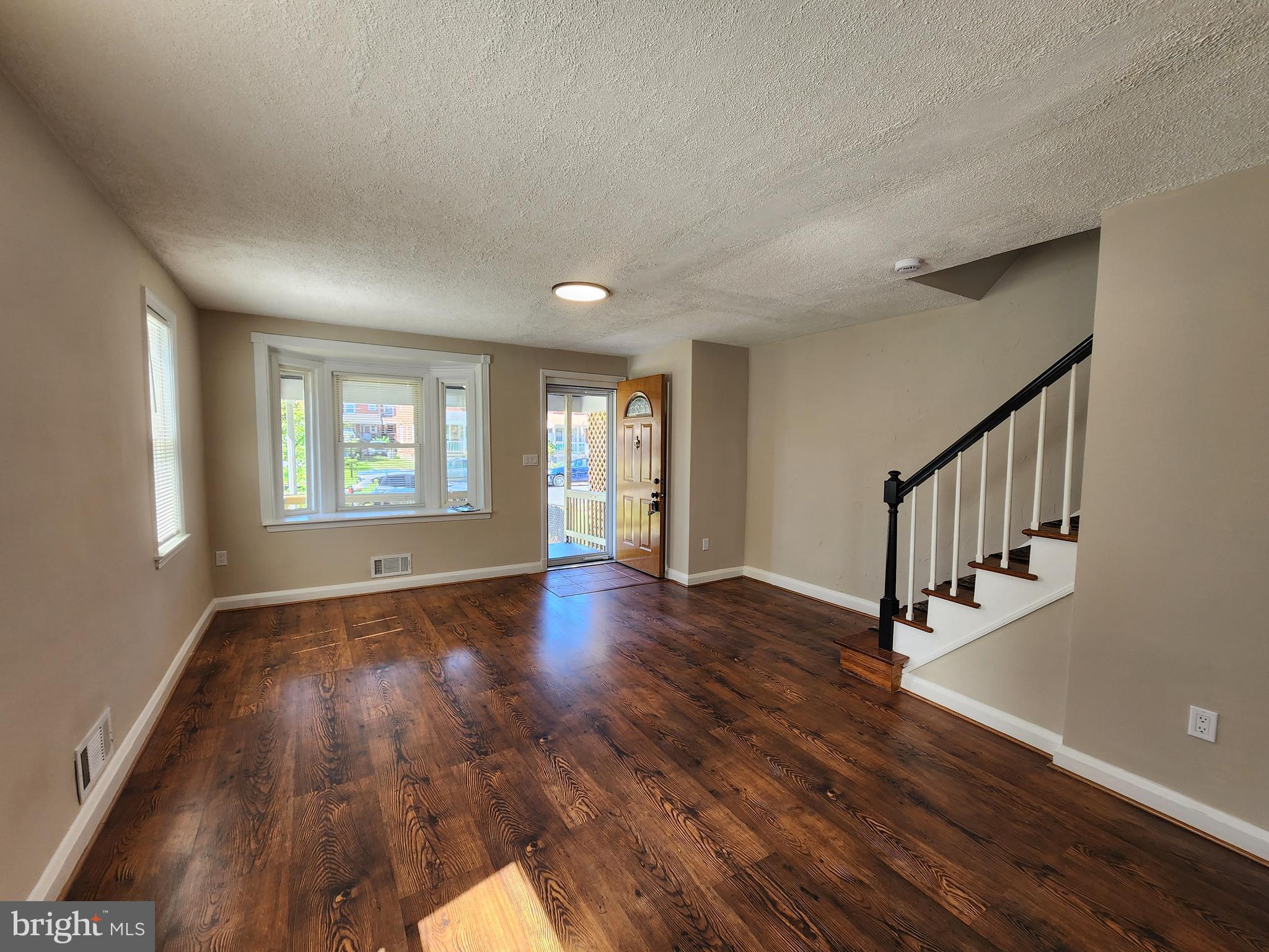 1925 Ewald Avenue Baltimore, MD 21222 - Photo 5 of 29 a view of an empty room with wooden floor and a window