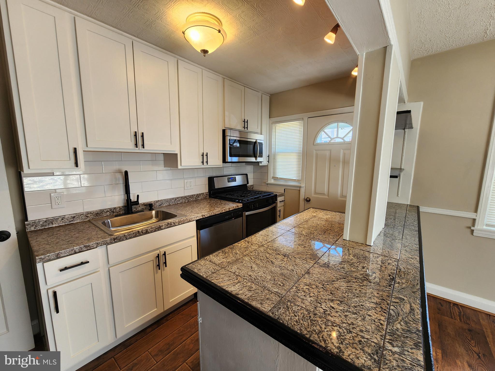 1925 Ewald Avenue Baltimore, MD 21222 - Photo 8 of 29 a kitchen with stainless steel appliances granite countertop a sink stove and refrigerator