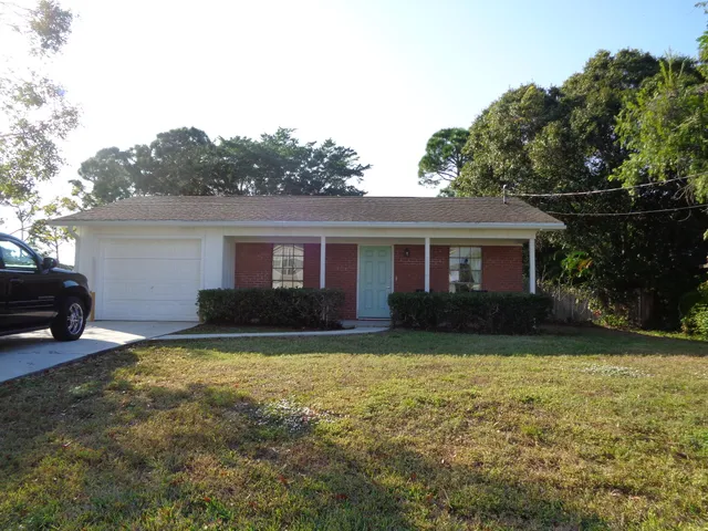 a view of a house with a yard and a tree
