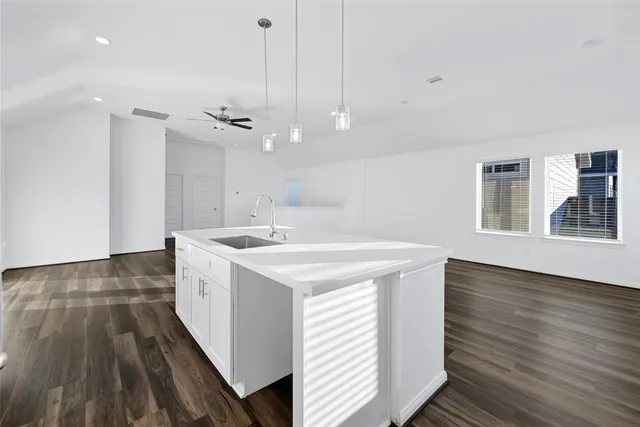 a kitchen with a sink and wooden floor