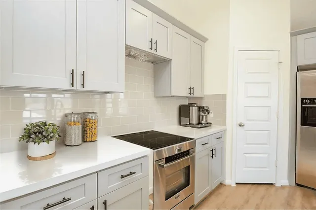 a kitchen with stainless steel appliances white cabinets and a stove