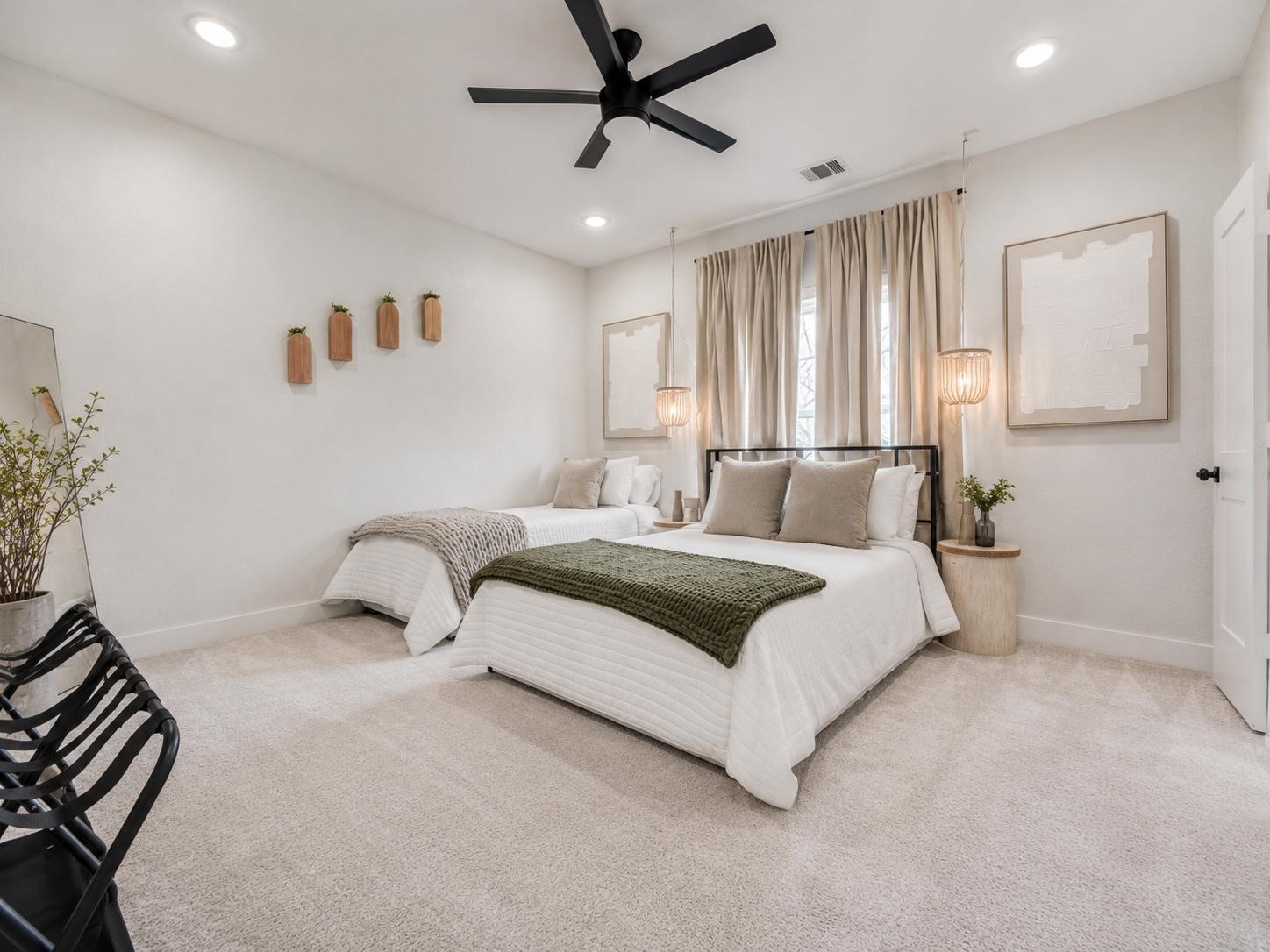 5407 Lee Street Houston, TX 77020 - Photo 9 of 17 This spacious bedroom features a modern design with neutral tones and cozy carpet. It includes a large bed with plush pillows, ambient lighting, and stylish wall decor, creating a warm and inviting atmosphere.