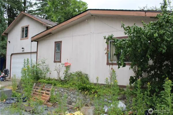 a backyard of a house with plants and outdoor seating