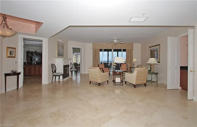 a living room with furniture and a dining table with wooden floor