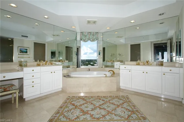 a large bathroom with a sink a large mirror and a bathtub