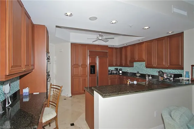 a kitchen with stainless steel appliances granite countertop a sink refrigerator and cabinets