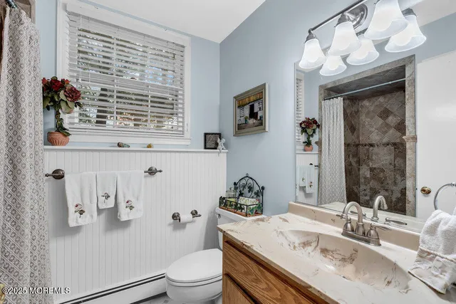 a bathroom with a sink a toilet and shower curtain