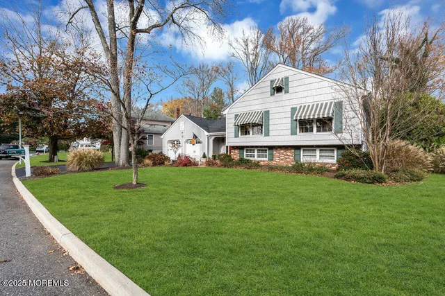 a front view of a house with a yard and trees