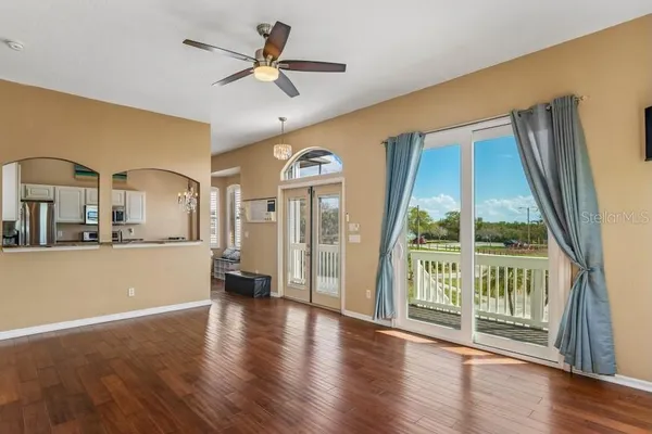 a living room with stainless steel appliances with wooden floor