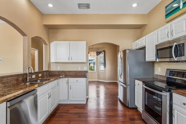 a kitchen with stainless steel appliances granite countertop a stove a sink and a microwave