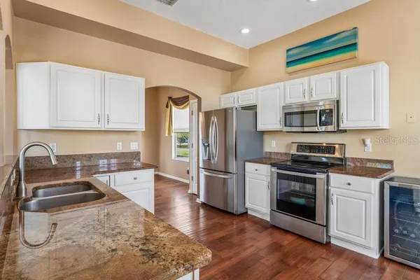 a kitchen with stainless steel appliances granite countertop a stove and a chandelier