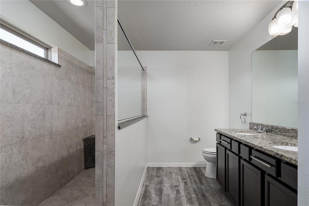 6026 100th Avenue East Parrish, FL 34219 - Photo 15 of 51 a bathroom with a granite countertop sink toilet and shower