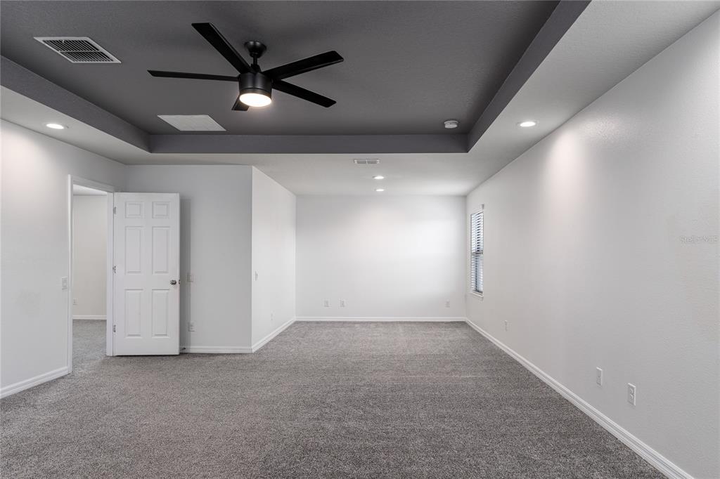 6026 100th Avenue East Parrish, FL 34219 - Photo 16 of 51 an empty room with ceiling fan and windows