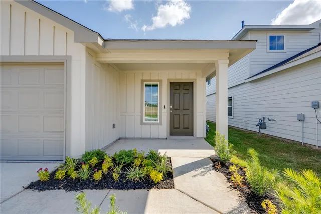 a front view of a house with a yard and flowers