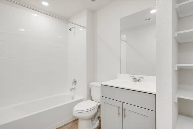 a kitchen with stainless steel appliances kitchen island granite countertop a sink and a stove top oven with wooden floor