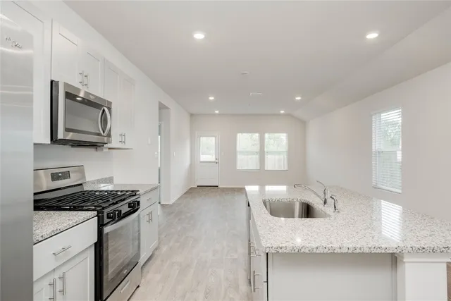 a kitchen with stainless steel appliances a stove microwave and refrigerator