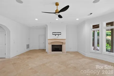 an empty room with fireplace and windows