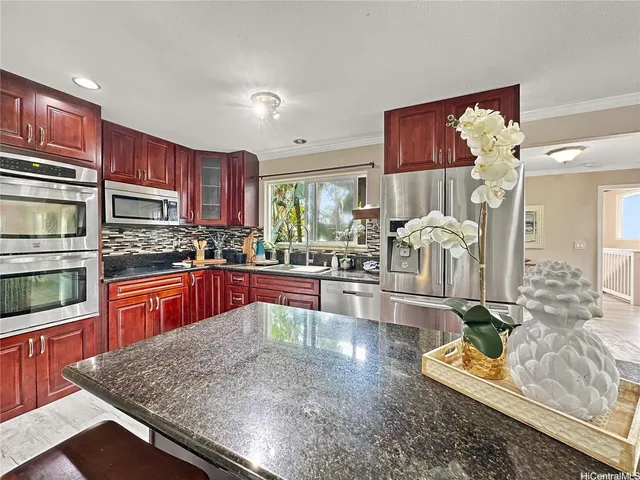 a large kitchen with stainless steel appliances granite countertop a granite counter tops and a view of living room