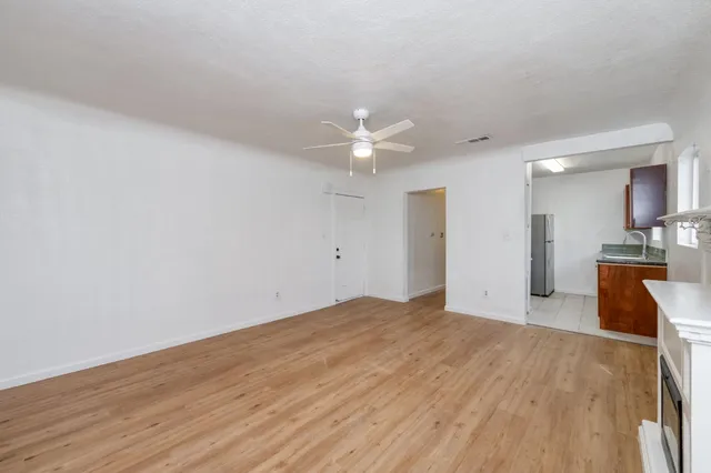 a view of a kitchen with wooden floor and a sink