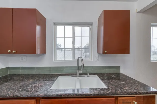 a kitchen with sink window and cabinets