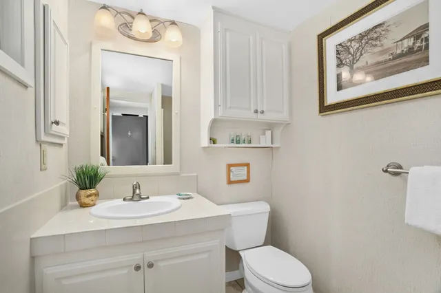 a bathroom with a sink mirror vanity and toilet