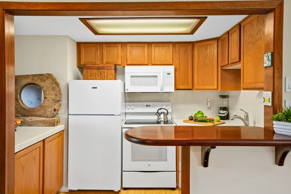 a kitchen with a sink a refrigerator and a stove top oven