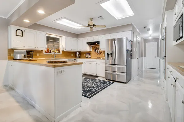 a kitchen with white cabinets and white appliances