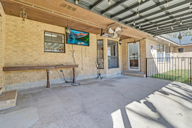 a view of a house with a big yard potted plants and large tree
