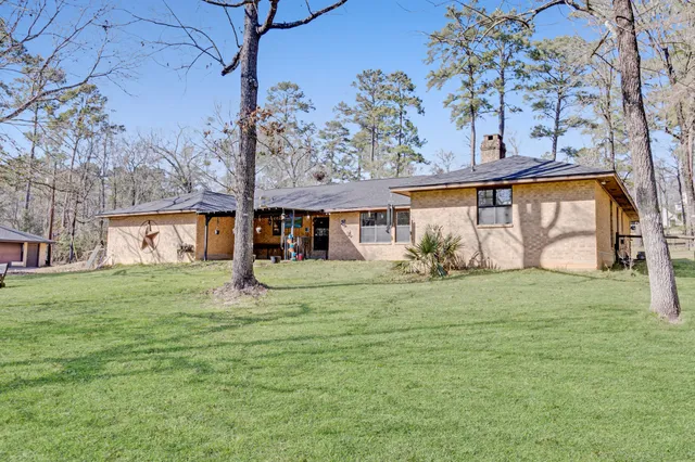 a view of a big house with a big yard and large trees