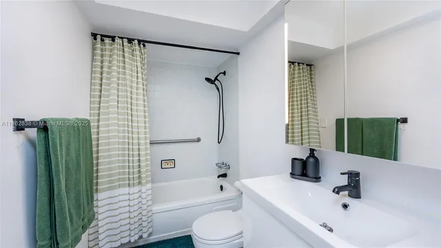a bathroom with a sink a toilet a mirror and shower