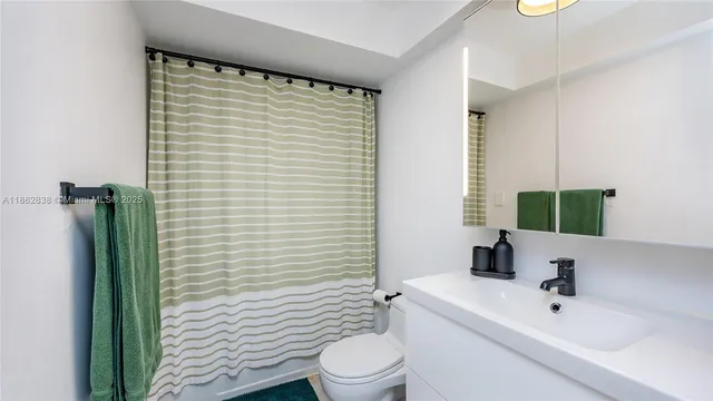 a view of a backyard with plants and large trees