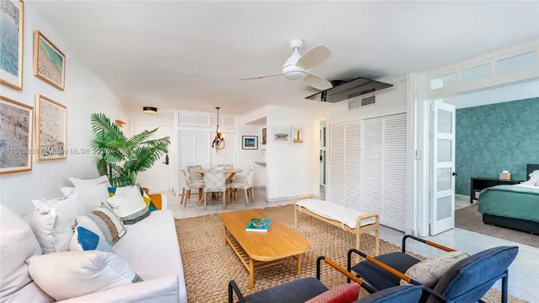 a living room with furniture kitchen view and a window